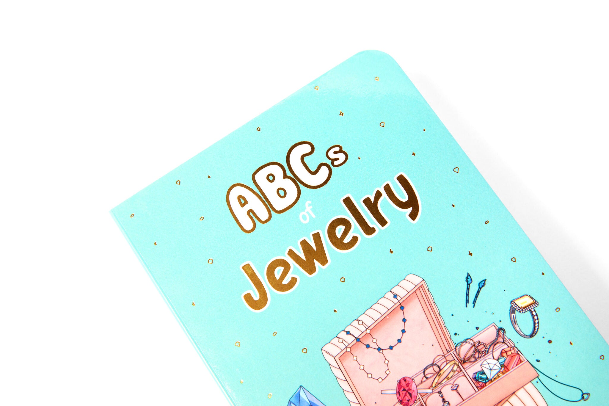 Premium children's book cover featuring a treasure chest of fine jewelry, diamonds and luxury accessories, aimed at teaching children the alphabet